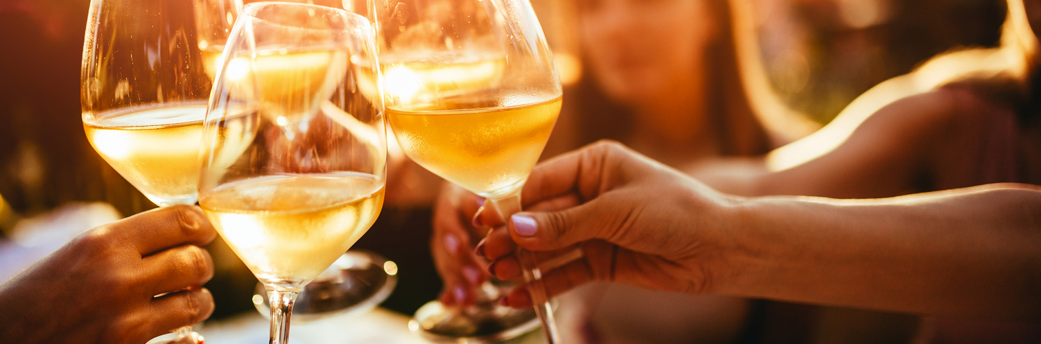 Menschen, die auf der Sommerterrasse eines Cafés mit Weingläsern anstoßen 