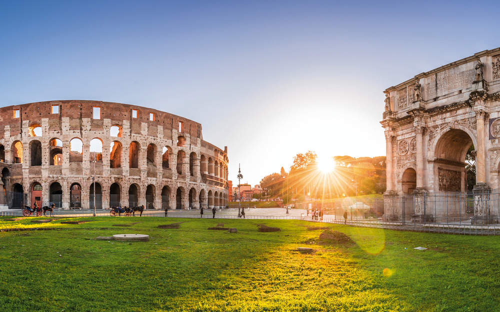 Panoramic view of Colosseum and Constantine arch at sunrise. Rom