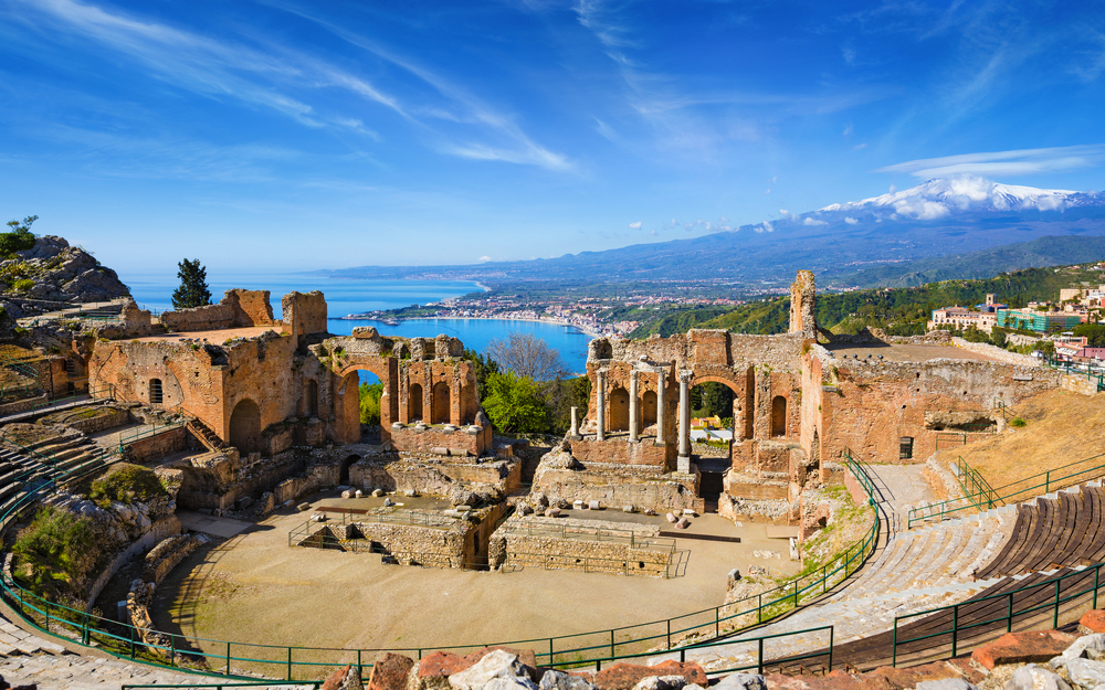 Ancient Greek theatre in Taormina on background of Etna Volcano, Italy