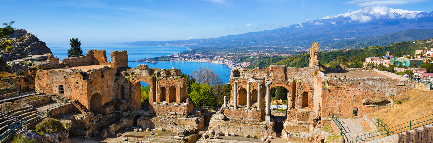 Ancient Greek theatre in Taormina on background of Etna Volcano, Italy