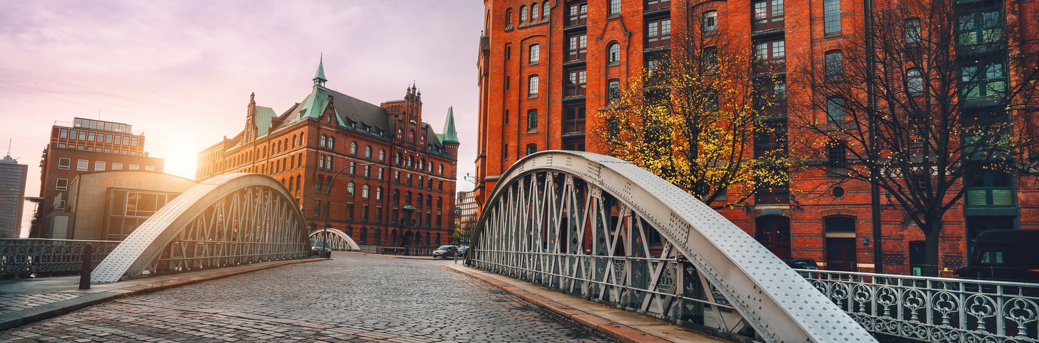 Bogenbrücke über die Alsterkanäle mit Kopfsteinpflasterstraße in der historischen Speicherstadt von Hamburg