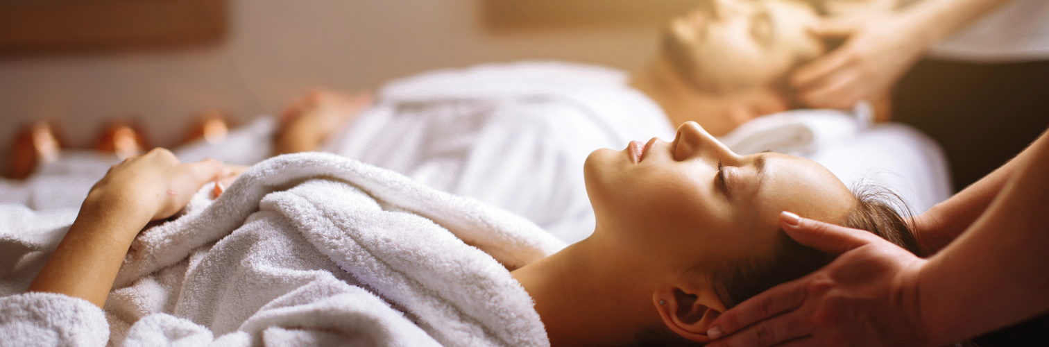 Young couple receiving head massage at beauty spa