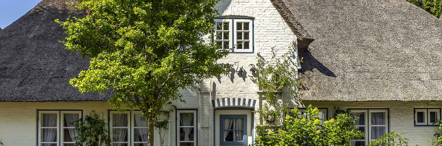 Friesenhaus mit Reetdach auf der Nordseeinsel Föhr