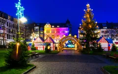 Weihnachtsmarkt am Abend mit bunten Lichtern und geschmücktem Weihnachtsbaum