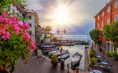 Sonnenaufgang im Hafen von Limone am Gardasee, Boote und mediterrane Umgebung.