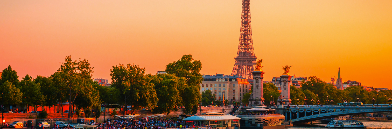 Blick auf den Eiffelturm, die Alexander-III.-Brücke und die Seine bei Sonnenuntergang in Paris, Frankreich