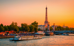Blick auf den Eiffelturm, die Alexander-III.-Brücke und die Seine bei Sonnenuntergang in Paris, Frankreich