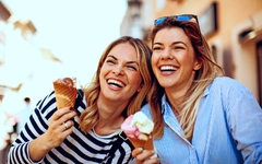Zwei junge Frauen lachen und halten Eis in der Hand