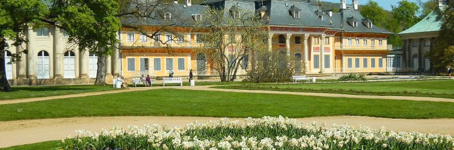 Schloss Pillnitz mit blühendem Garten im Vordergrund in Dresden.